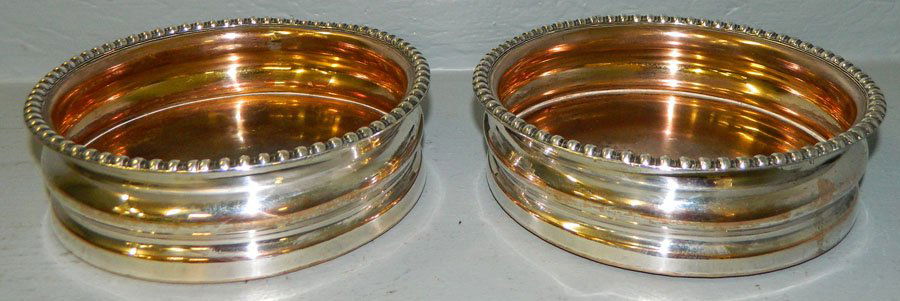 Pair of silver on copper wine coasters.: Pair of silver on copper wine coasters. 6" diameter.