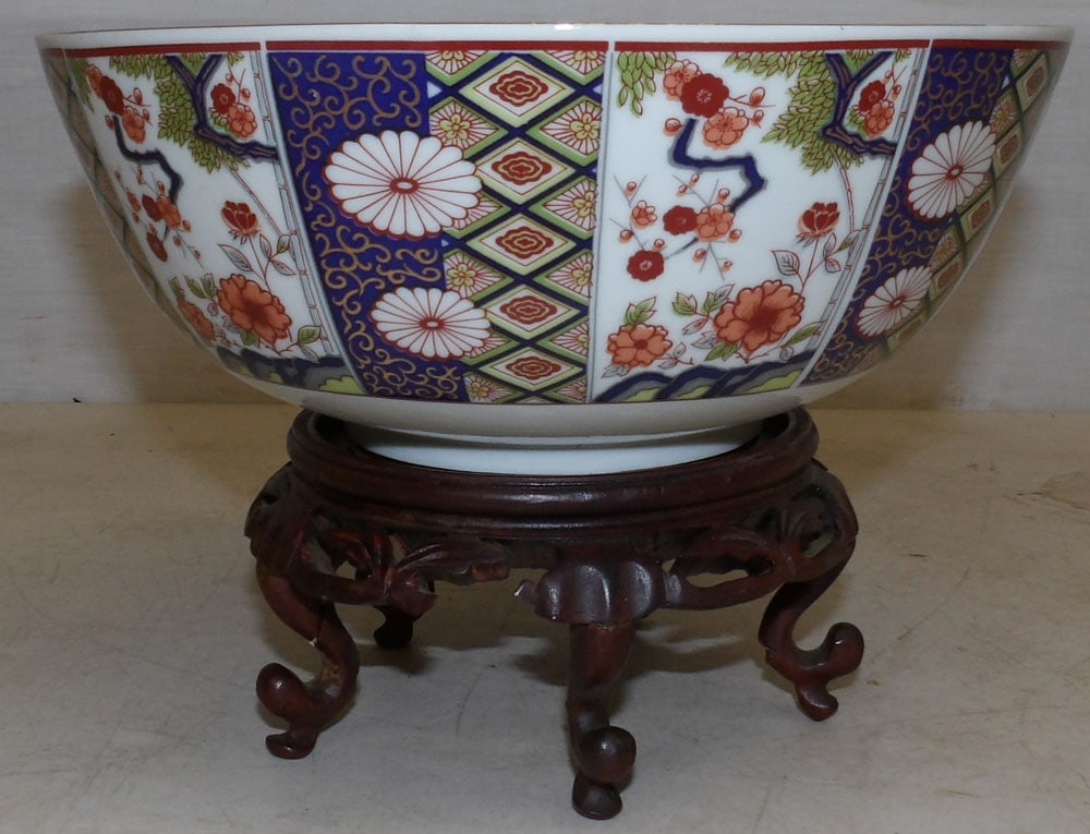 Oriental porcelain bowl on teak wood stand: Oriental porcelain bowl on teak wood stand. 9 1/4" Dia. 6 3/4" H "ALL DESCRIPTIONS AND ANY CONDITION STATEMENT GIVEN BY LANGSTON AUCTION GALLERY ARE STRICTLY OPINIONS AND LANGSTON'S SHALL HAVE NO RESP