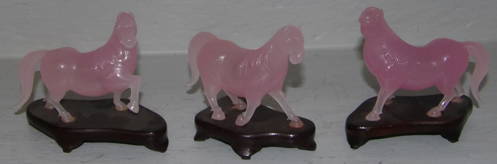 Three Pink Jade Chinese Horses on Teak Wood Stands: Three Pink Jade Chinese Horses on Teak Wood Stands . 3 1/2" H "ALL DESCRIPTIONS AND ANY CONDITION STATEMENT GIVEN BY LANGSTON AUCTION GALLERY ARE STRICTLY OPINIONS AND LANGSTON'S SHALL HAVE NO RESPONS