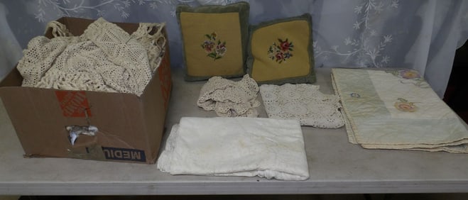 lot of crocheted coverlets and needlepoint pillows