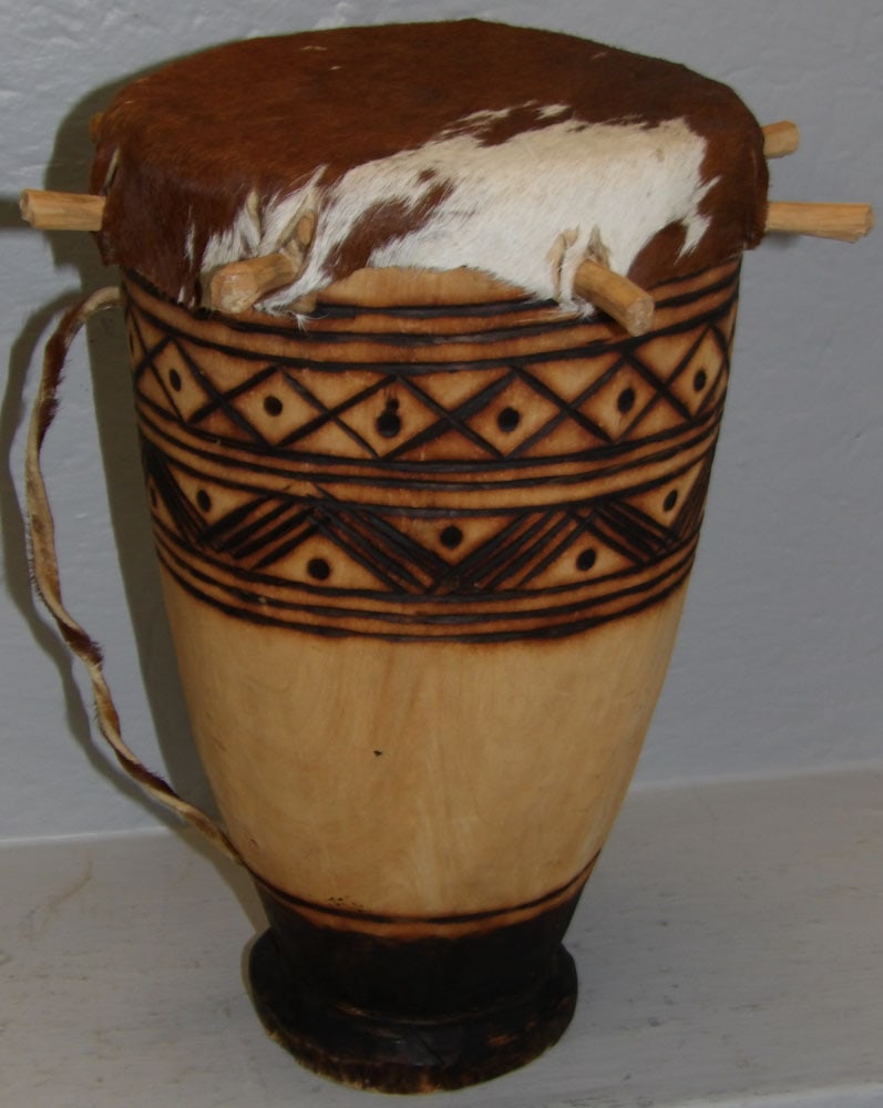 Carved African Wood Drum with Hyde Top: Carved African Wood Drum with Hyde Top . 8" Dia. 13" H "ALL DESCRIPTIONS AND ANY CONDITION STATEMENT GIVEN BY LANGSTON AUCTION GALLERY ARE STRICTLY OPINIONS AND LANGSTON'S SHALL HAVE NO RESPONSIBILITY