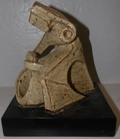 pottery sculpture on painted wood base
