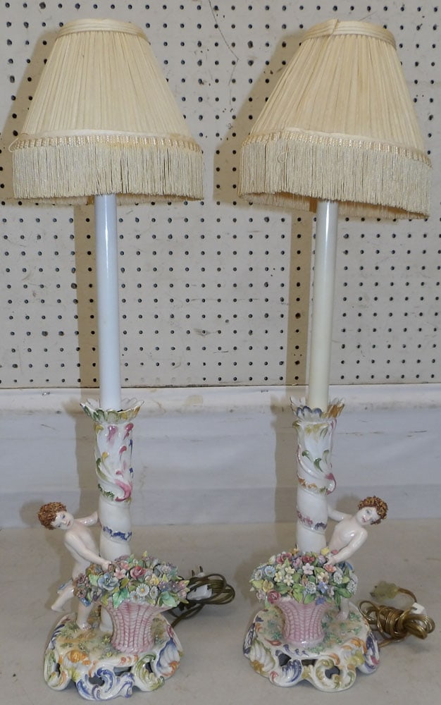 Pair of Painted Porcelain Capodimonte Cherub Candlestick Lamps, (Both Have Restoration): Pair of Painted Porcelain Capodimonte Cherub Candlestick Lamps, (Both Have Restoration). 27" H "ALL DESCRIPTIONS AND ANY CONDITION STATEMENT GIVEN BY LANGSTON AUCTION GALLERY ARE STRICTLY OPINIONS AND
