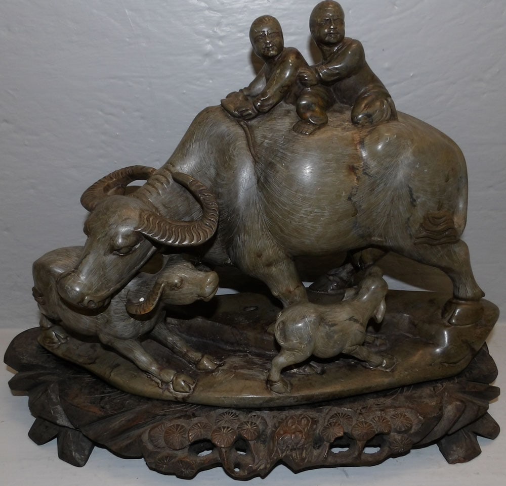 Chinese carved soapstone water buffalo on teakwood stand: Chinese carved soapstone water buffalo on teakwood stand . 16" W 12 1/4" H "ALL DESCRIPTIONS AND ANY CONDITION STATEMENT GIVEN BY LANGSTON AUCTION GALLERY ARE STRICTLY OPINIONS AND LANGSTON'S SHALL HA