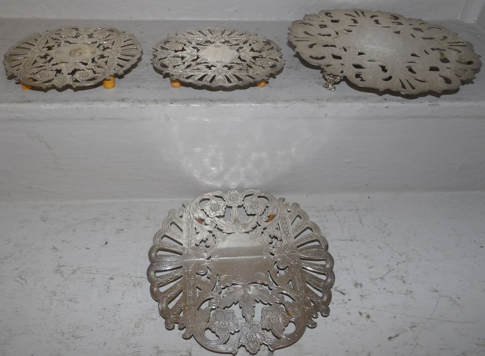 Four Silver Plated Trivets: Four Silver Plated Trivets . 9 1/4" Dia. ALL DESCRIPTIONS AND ANY CONDITION STATEMENT GIVEN BY LANGSTON AUCTION GALLERY ARE STRICTLY OPINIONS AND LANGSTON'S SHALL HAVE NO RESPONSIBILITY FOR ERRORS OR