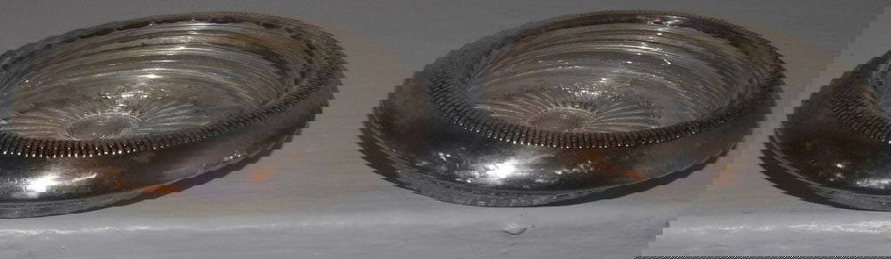 Two Sterling Rim Glass Coasters: Two Sterling Rim Glass Coasters. 4" Dia. ALL DESCRIPTIONS AND ANY CONDITION STATEMENT GIVEN BY LANGSTON AUCTION GALLERY ARE STRICTLY OPINIONS AND LANGSTON'S SHALL HAVE NO RESPONSIBILITY FOR ERRORS OR