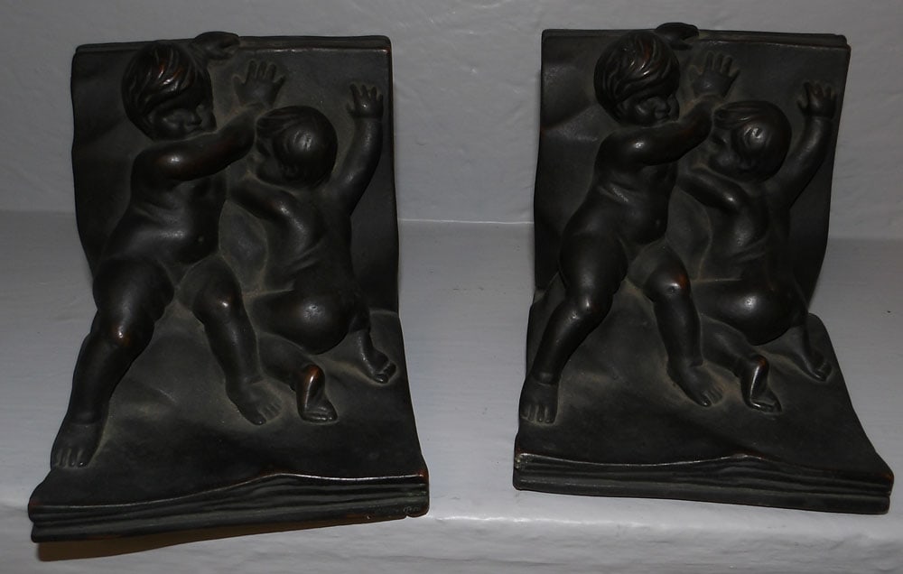 pair of painted ceramic cherub book ends: pair of painted ceramic cherub book ends. 5" H 4 1/2" W 5" D ALL DESCRIPTIONS AND ANY CONDITION STATEMENT GIVEN BY LANGSTON AUCTION GALLERY ARE STRICTLY OPINIONS AND LANGSTON'S SHALL HAVE NO RESPONSIB