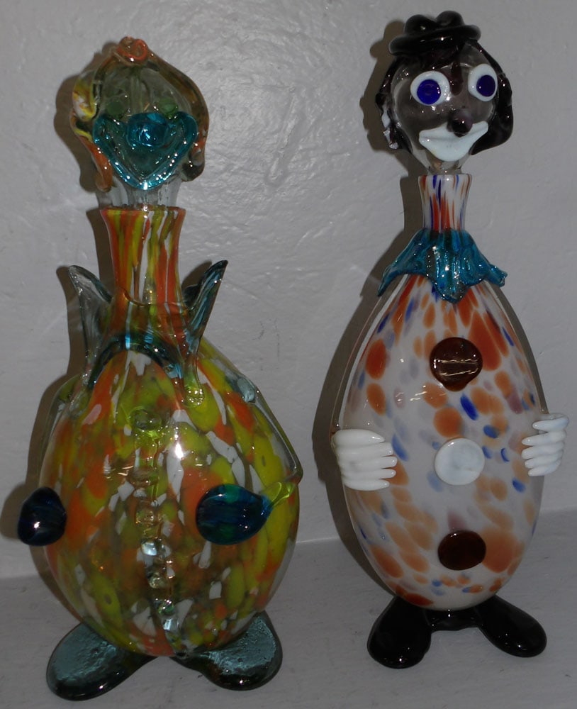 Two Art Glass Clown Form Decanters, (One Ear Damaged): Two Art Glass Clown Form Decanters, (One Ear Damaged). 16 3/4" H 7" Dia. ALL DESCRIPTIONS AND ANY CONDITION STATEMENT GIVEN BY LANGSTON AUCTION GALLERY ARE STRICTLY OPINIONS AND LANGSTON'S SHALL HAVE 