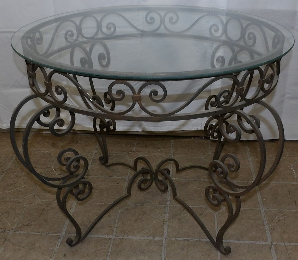 Wrought Iron & Glass Top Table: Wrought Iron & Glass Top Table. 21 3/4" H 34" Dia. ALL DESCRIPTIONS AND ANY CONDITION STATEMENT GIVEN BY LANGSTON AUCTION GALLERY ARE STRICTLY OPINIONS AND LANGSTON'S SHALL HAVE NO RESPONSIBILITY FOR