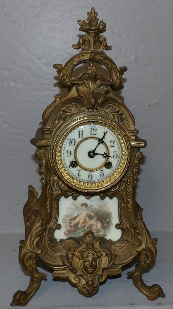 Antique Painted Metal French Clock with Porcelain Plaque & Waterbury Works: Antique Painted Metal French Clock with Porcelain Plaque & Waterbury Works. 15" H 8 1/4" W 6" D ALL DESCRIPTIONS AND ANY CONDITION STATEMENT GIVEN BY LANGSTON AUCTION GALLERY ARE STRICTLY OPINIONS AND