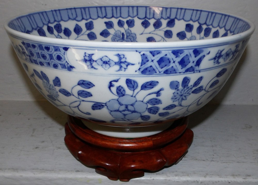 Oriental Blue & White Bowl On Teak Wood Stand: Oriental Blue & White Bowl On Teak Wood Stand. 7 1/2" H 12" Dia ALL DESCRIPTIONS AND ANY CONDITION STATEMENT GIVEN BY LANGSTON AUCTION GALLERY ARE STRICTLY OPINIONS AND LANGSTON'S SHALL HAVE NO RESPON