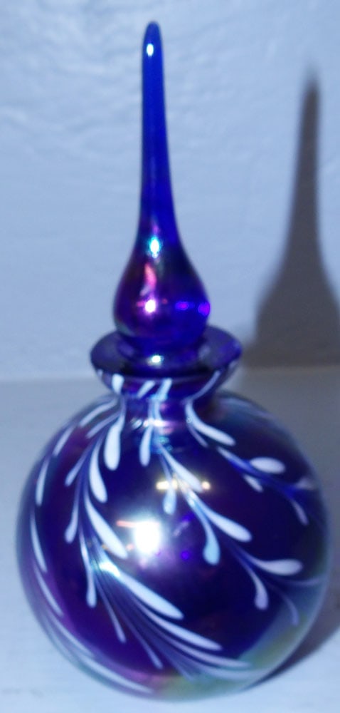 Iridescent Glass Scent Bottle: Iridescent Glass Scent Bottle. 6" H 3" Dia ALL DESCRIPTIONS AND ANY CONDITION STATEMENT GIVEN BY LANGSTON AUCTION GALLERY ARE STRICTLY OPINIONS AND LANGSTON'S SHALL HAVE NO RESPONSIBILITY FOR ERRORS O
