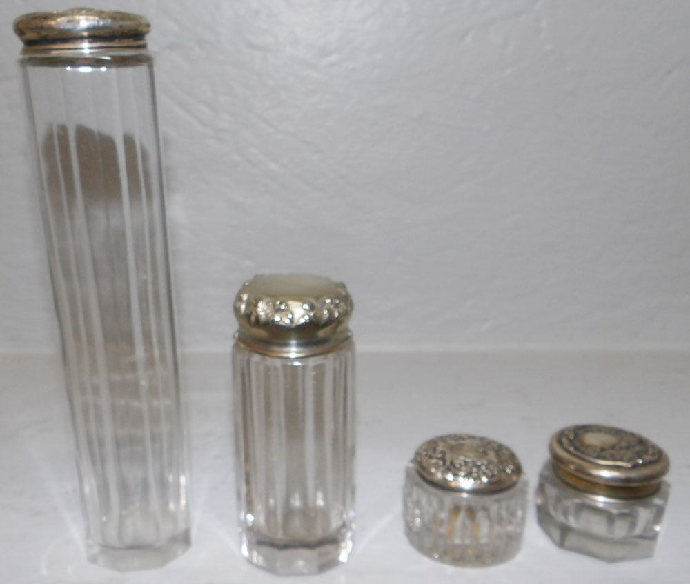 Four Glass Dresser Jars With Sterling Tops: Four Glass Dresser Jars With Sterling Tops. Up To 7" H 1 1/2" Dia ALL DESCRIPTIONS AND ANY CONDITION STATEMENT GIVEN BY LANGSTON AUCTION GALLERY ARE STRICTLY OPINIONS AND LANGSTON'S SHALL HAVE NO RESP