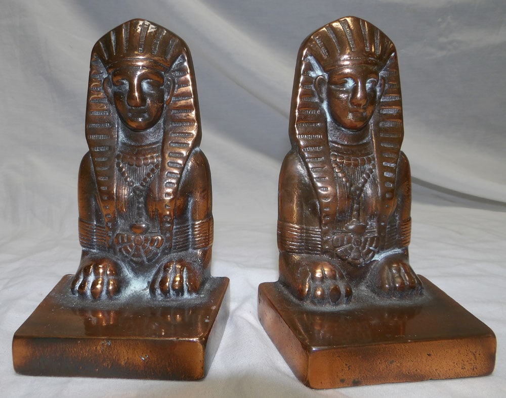 Pair Copper Finish Cast Iron Bookends: Pair Copper Finish Cast Iron Bookends. 6" H 3 1/2" W 2 1/2" D ALL DESCRIPTIONS AND ANY CONDITION STATEMENT GIVEN BY LANGSTON AUCTION GALLERY ARE STRICTLY OPINIONS AND LANGSTON'S SHALL HAVE NO RESPONSI