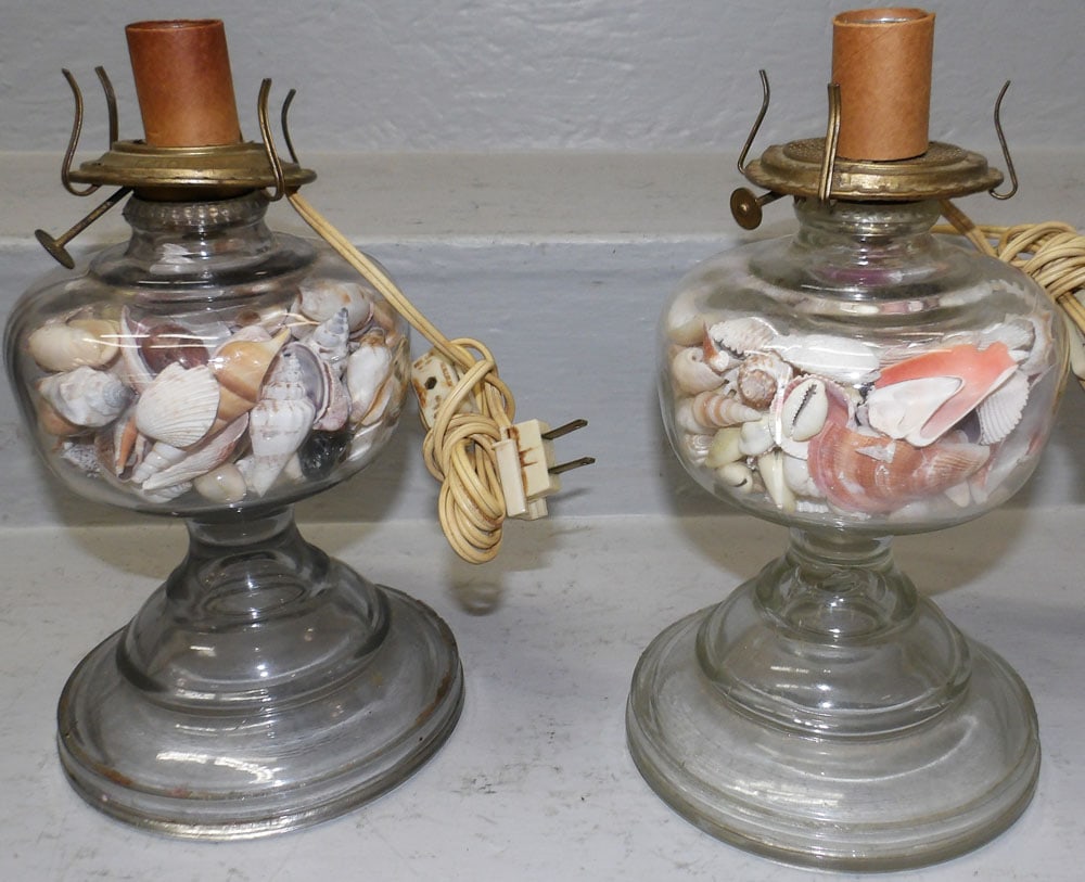 Pair of Glass Electrified Oil Lamps with Sea Shells: Pair of Glass Electrified Oil Lamps with Sea Shells. 10 1/4" H 5" Dia. "ALL DESCRIPTIONS AND ANY CONDITION STATEMENT GIVEN BY LANGSTON AUCTION GALLERY ARE STRICTLY OPINIONS AND LANGSTON'S SHALL HAVE N