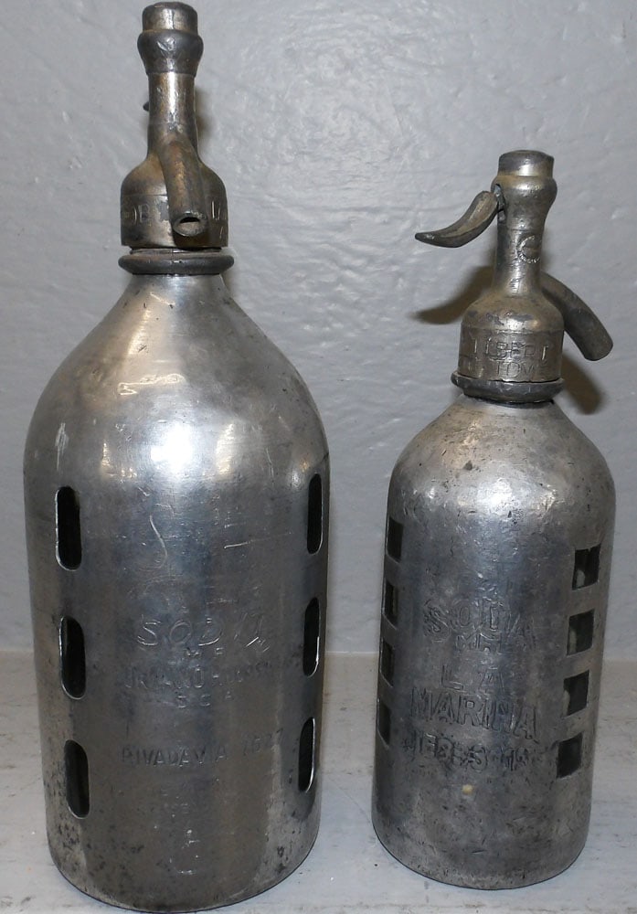 Two Aluminum & Glass Soda Bottles: Two Aluminum & Glass Soda Bottles. Up to 12" H 4" Dia. "ALL DESCRIPTIONS AND ANY CONDITION STATEMENT GIVEN BY LANGSTON AUCTION GALLERY ARE STRICTLY OPINIONS AND LANGSTON'S SHALL HAVE NO RESPONSIBILITY