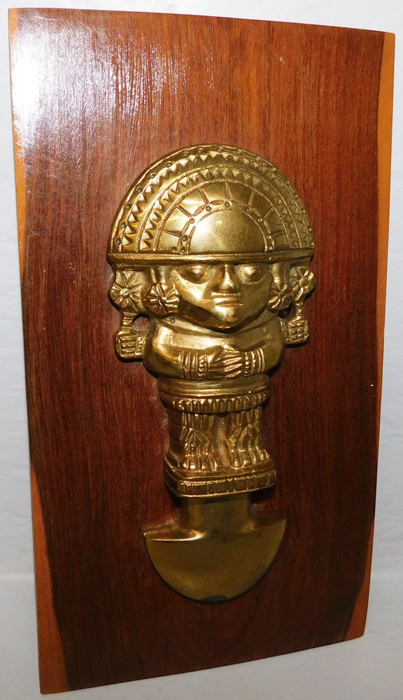 Brass Peruvian Tumi Knife on Cedar Wood Plaque: Brass Peruvian Tumi Knife on Cedar Wood Plaque . 10" x 5 3/4" ALL DESCRIPTIONS AND ANY CONDITION STATEMENT GIVEN BY LANGSTON AUCTION GALLERY ARE STRICTLY OPINIONS AND LANGSTON'S SHALL HAVE NO