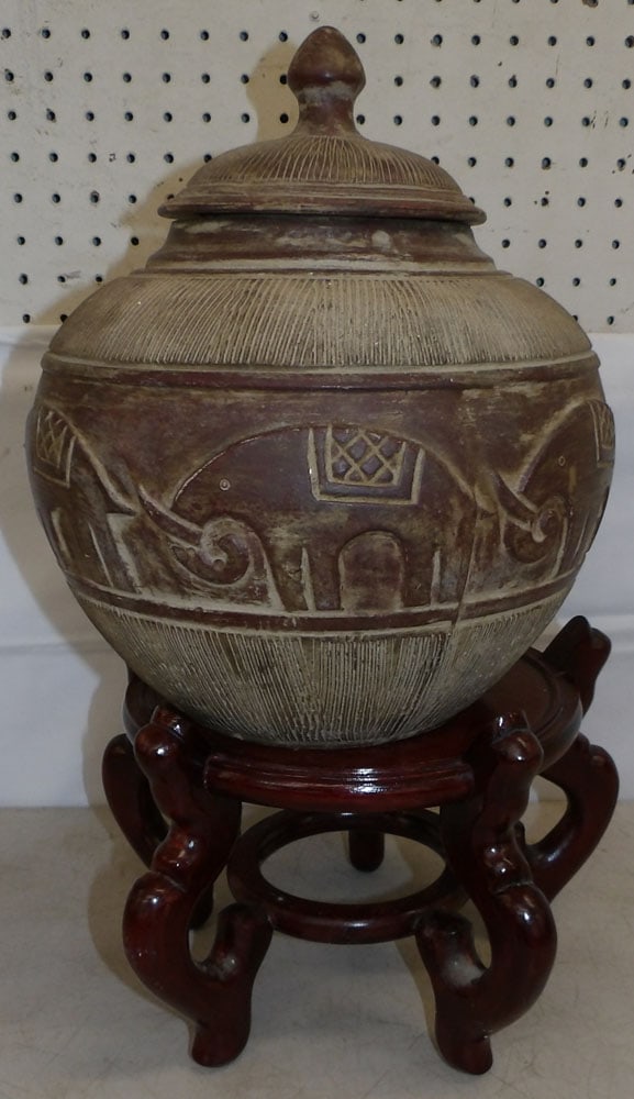 Ceramic Covered Urn on Teak Wood Stand: Ceramic Covered Urn on Teak Wood Stand . 12 3/4" H 11" Dia. ALL DESCRIPTIONS AND ANY CONDITION STATEMENT GIVEN BY LANGSTON AUCTION GALLERY ARE STRICTLY OPINIONS AND LANGSTON'S SHALL HAVE NO RESPONSIBI