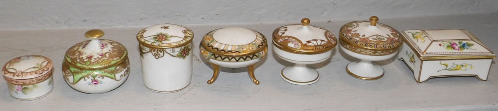 Seven Antique Nippon Porcelain Covered Trinket or Ring Boxes, (Two Pedestal, One Footed): Seven Antique Nippon Porcelain Covered Trinket or Ring Boxes, (Two Pedestal, One Footed). 1 1/2" H 3 1/4" W 2 1/2" D ALL DESCRIPTIONS AND ANY CONDITION STATEMENT GIVEN BY LANGSTON AUCTION GALLERY