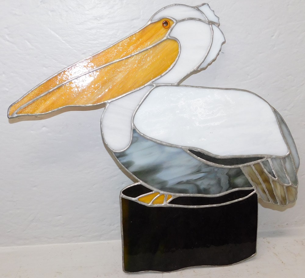 Leaded & Stained Glass Pelican Form Sun Catcher: Leaded & Stained Glass Pelican Form Sun Catcher. 16 1/4" x 18 1/4" ALL DESCRIPTIONS AND ANY CONDITION STATEMENT GIVEN BY LANGSTON AUCTION GALLERY ARE STRICTLY OPINIONS AND LANGSTON'S SHALL HAVE NO
