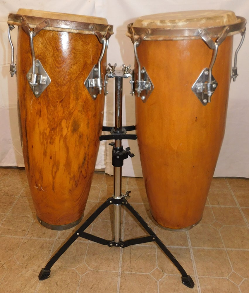 Two Wood & Animal Hyde Konga Drums on Metal Stand: Two Wood & Animal Hyde Konga Drums on Metal Stand. 28 3/4" H 13" Dia. ALL DESCRIPTIONS AND ANY CONDITION STATEMENT GIVEN BY LANGSTON AUCTION GALLERY ARE STRICTLY OPINIONS AND LANGSTON'S SHALL HAVE NO 
