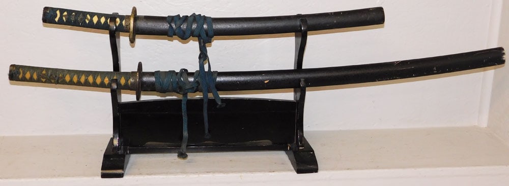 Two Samurai Swords on Wood Stand: Two Samurai Swords on Wood Stand . Up to 41" L ALL DESCRIPTIONS AND ANY CONDITION STATEMENT GIVEN BY LANGSTON AUCTION GALLERY ARE STRICTLY OPINIONS AND LANGSTON'S SHALL HAVE NO RESPONSIBILITY FOR
