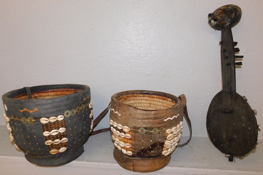Two Leather & Shell Decorated Tribal Baskets & Musical Instrument: Two Leather & Shell Decorated Tribal Baskets & Musical Instrument. Up to 20" L ALL DESCRIPTIONS AND ANY CONDITION STATEMENT GIVEN BY LANGSTON AUCTION GALLERY ARE STRICTLY OPINIONS AND LANGSTON'S SHALL