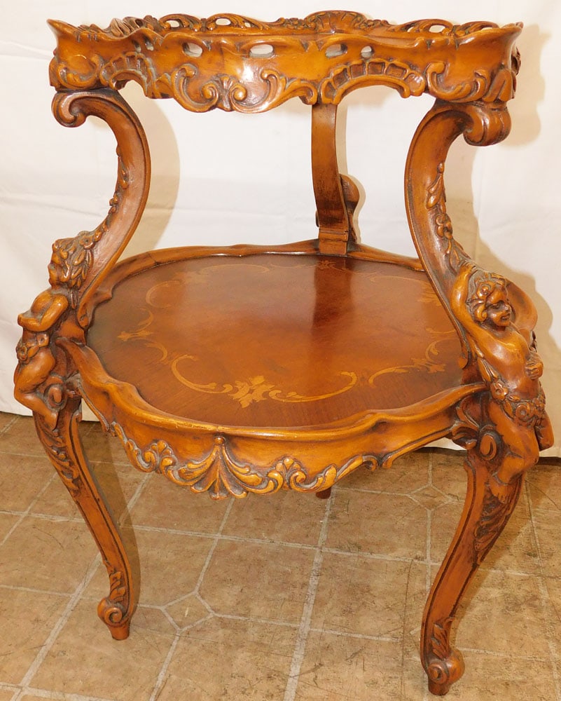 Carved Walnut Inlaid French Two Tier Table with Cherub Accents: Carved Walnut Inlaid French Two Tier Table with Cherub Accents . 28 1/4" H 23 1/2" Dia. ALL DESCRIPTIONS AND ANY CONDITION STATEMENT GIVEN BY LANGSTON AUCTION GALLERY ARE STRICTLY OPINIONS AND