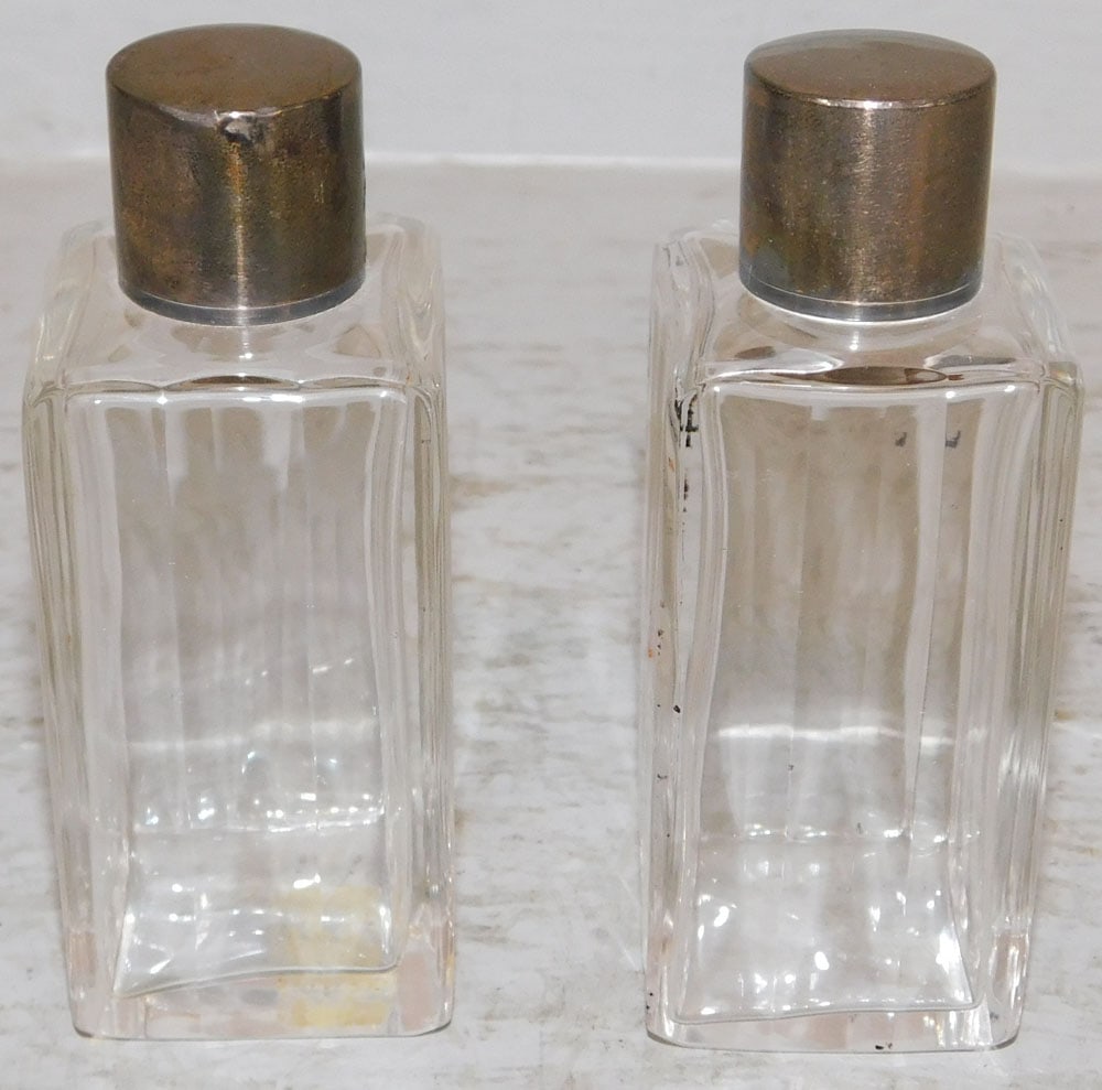 Two Sterling Top Perfume Bottles: Two Sterling Top Perfume Bottles . 4" H 1 1/2" Dia. ALL DESCRIPTIONS AND ANY CONDITION STATEMENT GIVEN BY LANGSTON AUCTION GALLERY ARE STRICTLY OPINIONS AND LANGSTON'S SHALL HAVE NO RESPONSIBILITY