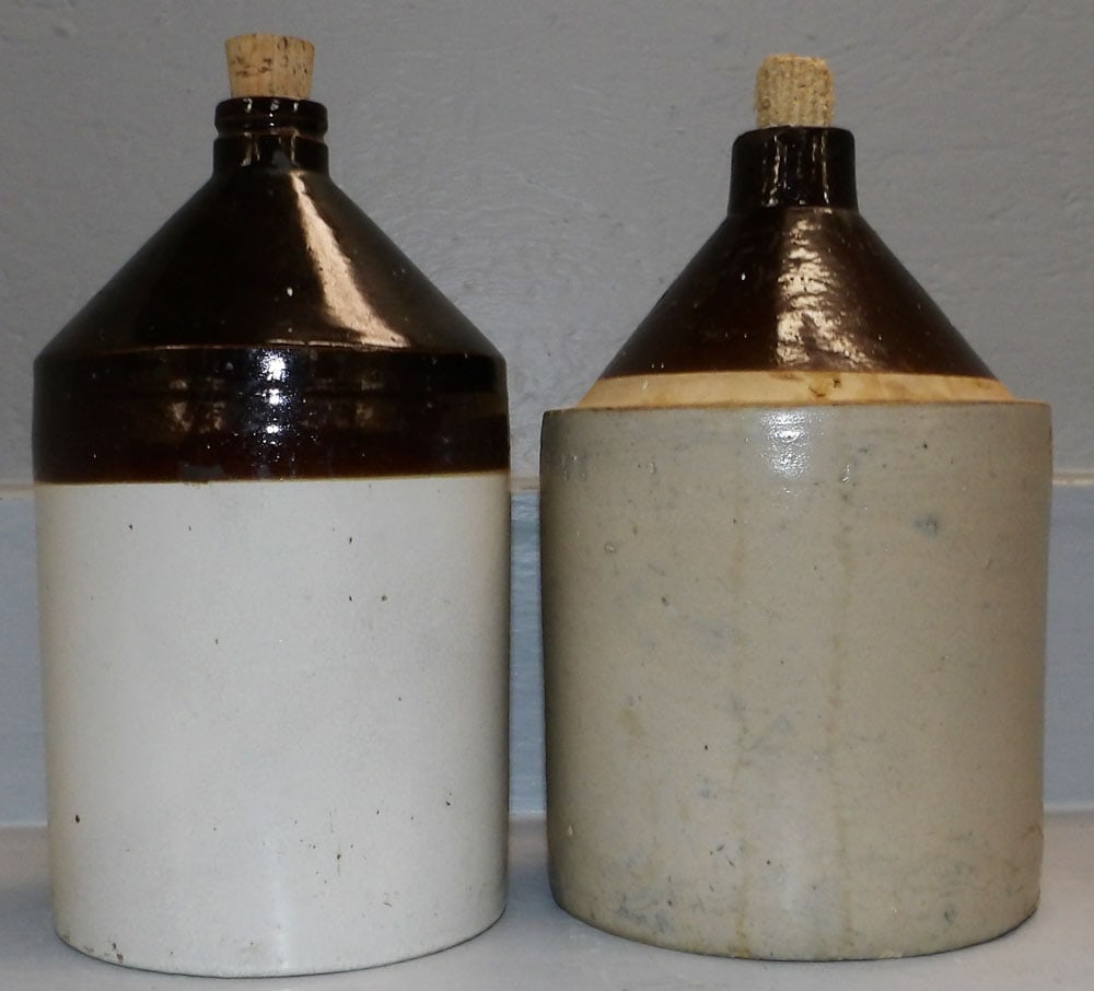 Two Stoneware Whisky Jugs: Two Stoneware Whisky Jugs. 11 1/2" H 6 1/4" Dia. "ALL DESCRIPTIONS AND ANY CONDITION STATEMENT GIVEN BY LANGSTON AUCTION GALLERY ARE STRICTLY OPINIONS AND LANGSTON'S SHALL HAVE NO RESPONSIBILITY FOR
