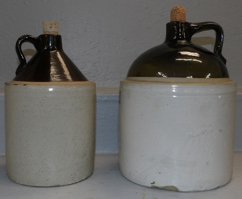 Two Stoneware Whisky Jugs: Two Stoneware Whisky Jugs. 12 1/2" H 9" Dia. "ALL DESCRIPTIONS AND ANY CONDITION STATEMENT GIVEN BY LANGSTON AUCTION GALLERY ARE STRICTLY OPINIONS AND LANGSTON'S SHALL HAVE NO RESPONSIBILITY FOR