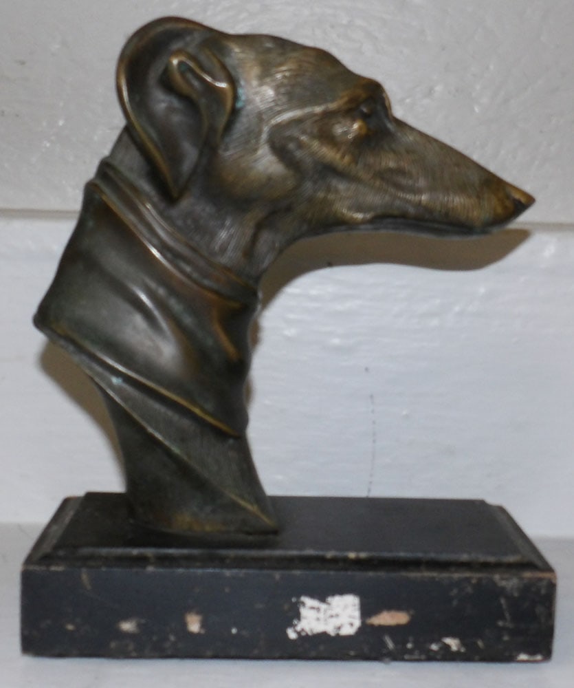 Bronze Whippet Head Statue on Painted Wood Base: Bronze Whippet Head Statue on Painted Wood Base. 9" H 7 1/2" W 4" D "ALL DESCRIPTIONS AND ANY CONDITION STATEMENT GIVEN BY LANGSTON AUCTION GALLERY ARE STRICTLY OPINIONS AND LANGSTON'S SHALL HAVE NO