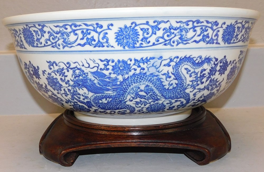 Oriental Blue & White Bowl with Dragon Motif on Teak Wood Stand: Oriental Blue & White Bowl with Dragon Motif on Teak Wood Stand . 7" H 16 1/4" Dia. "ALL DESCRIPTIONS AND ANY CONDITION STATEMENT GIVEN BY LANGSTON AUCTION GALLERY ARE STRICTLY OPINIONS AND LANGSTON'S