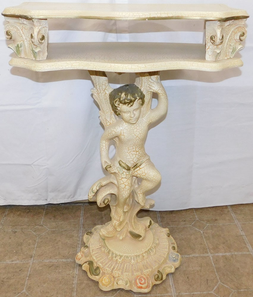 Painted Resin Figural Cupid Wall Pedestal: Painted Resin Figural Cupid Wall Pedestal . 31 1/2" H 23 1/4" W 10 1/2" D "ALL DESCRIPTIONS AND ANY CONDITION STATEMENT GIVEN BY LANGSTON AUCTION GALLERY ARE STRICTLY OPINIONS AND LANGSTON'S SHALL