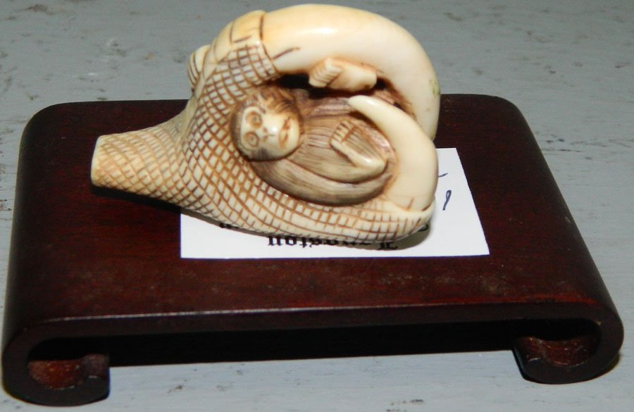 Ivory netsuke of eagle claw with monkey.: Ivory netsuke of eagle claw with monkey. 1 1/2".