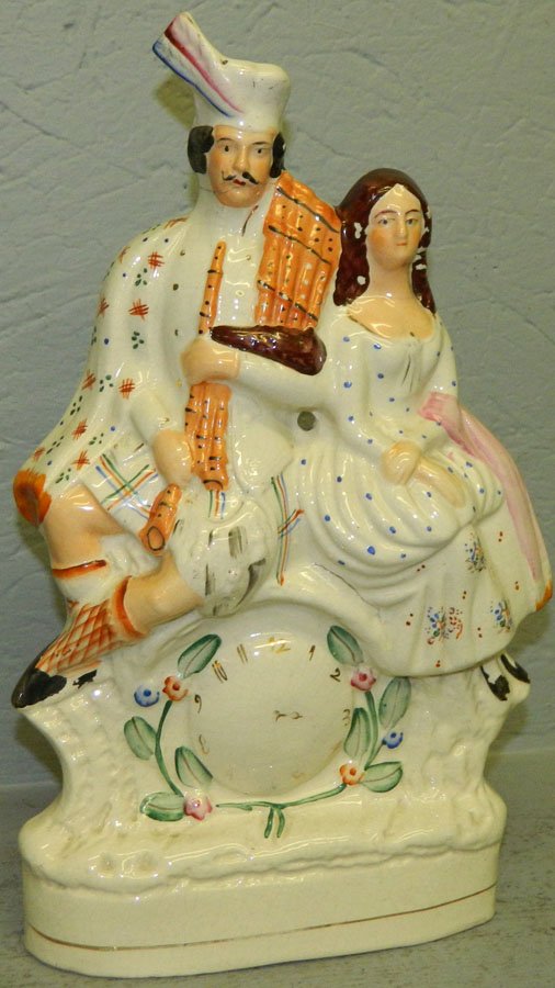 19th C Staffordshire figure of a man and lady.: 19th Century Staffordshire figure of a man and lady on clock. 14" tall.