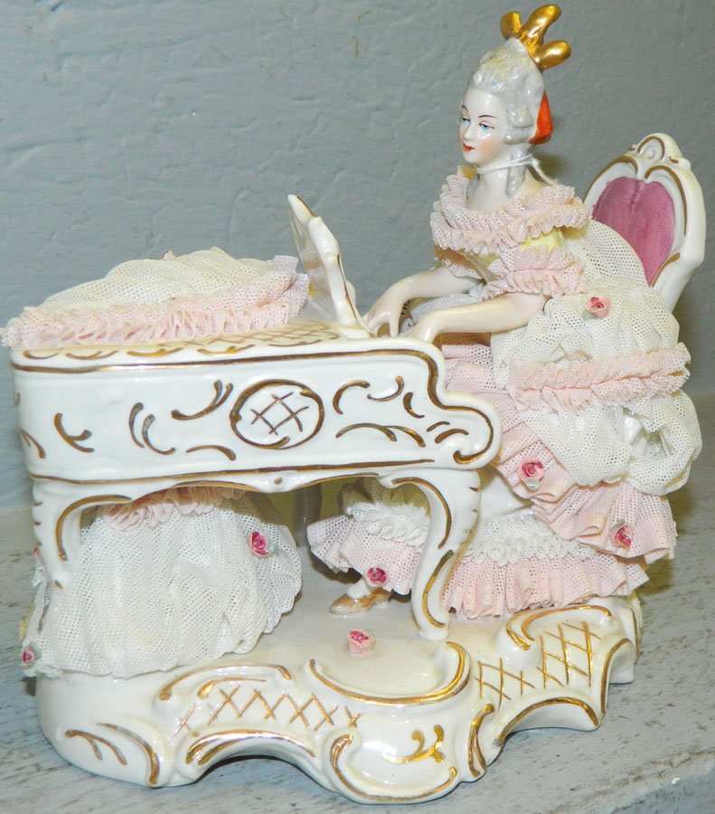 Dresden figure of a lady playing piano.: Dresden figure of a lady playing piano, some loss in skirt and on piano. 7" long x 6 1/4" tall.