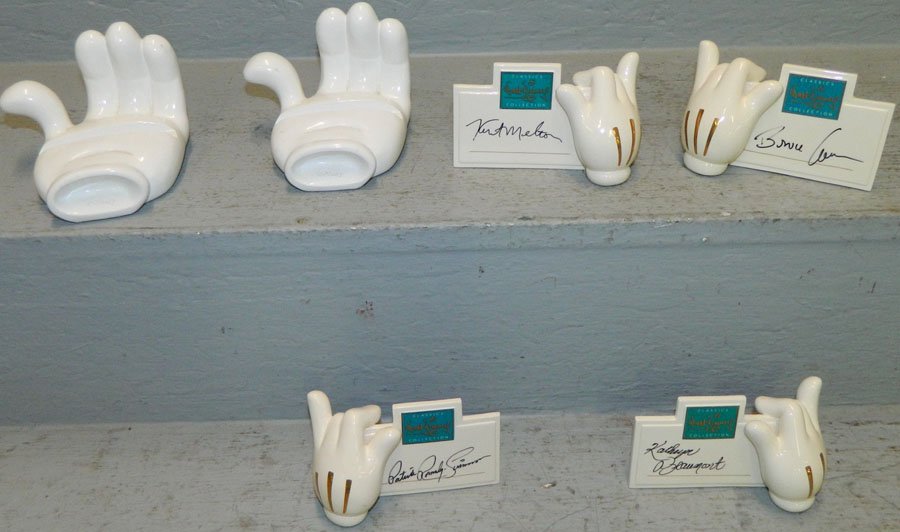 Designer signature plaques and two card holders.: Collection of four Disney designer signature plaques with signatures and two Mickey hand card holders.