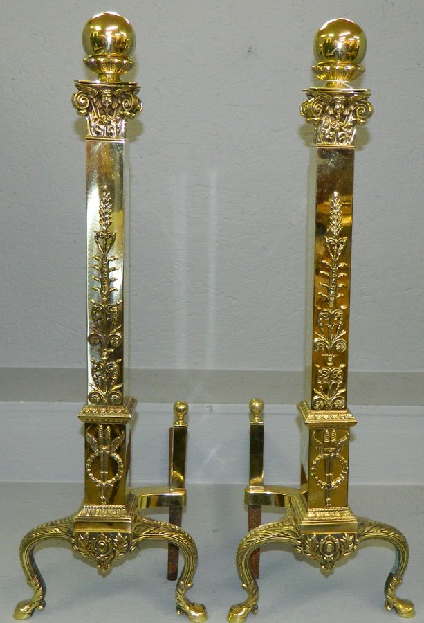Pair of polished brass andirons. 29 1/2" tall.: Pair of polished brass andirons with heavy leaf motif and jellif heads. 29 1/2" tall.