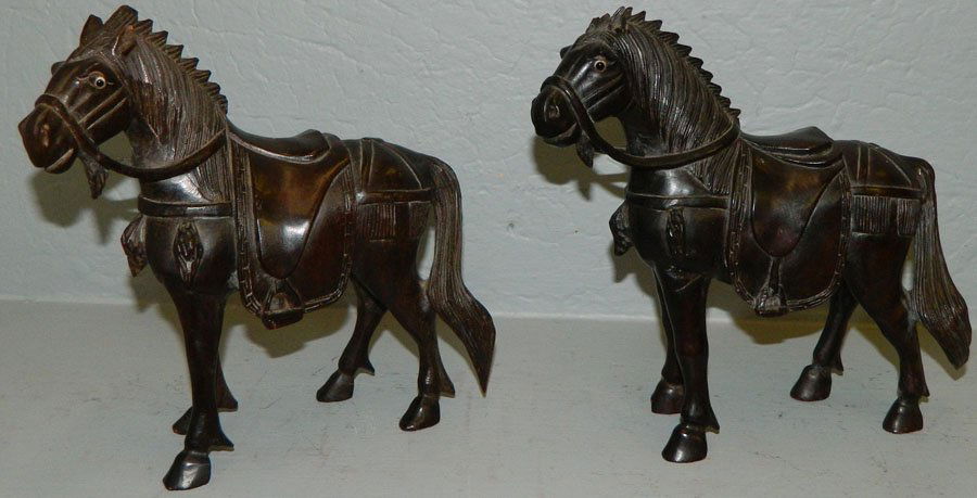 Pair of hand carved black ebony horses.: Pair of hand carved black ebony horses. One horse has broken ear. 8" tall.