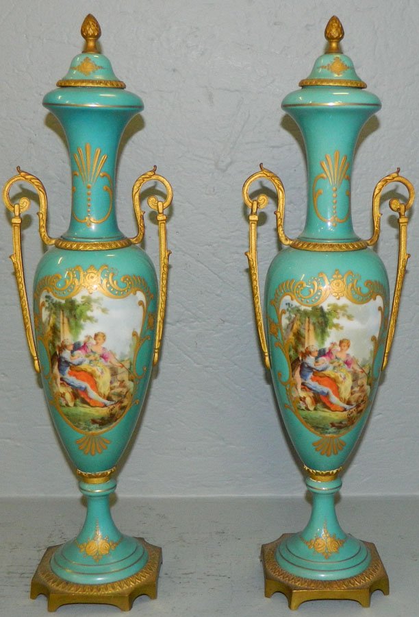 Pair of French porcelain hand painted urns.: Pair of French porcelain hand painted urns with ormolu, artist signed. 17 1/4" tall.