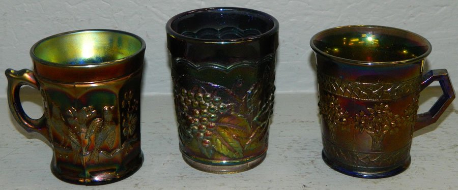 Carnival glass tumbler and two mugs: Purple grape and cable tumbler, Northwood singing bird mug and floral bouquet pattern mug.3 1/2" to 4" tall.
