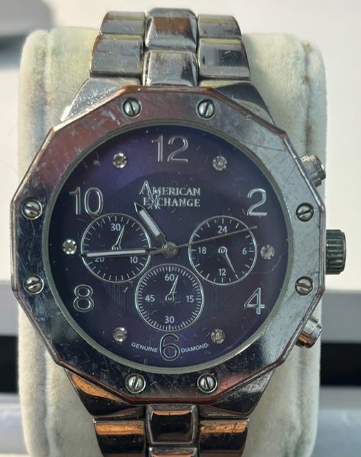 American Exchange by Bulova: Silver toned metal with an 8-Sided octagonal bezel.Deep blue/purple face