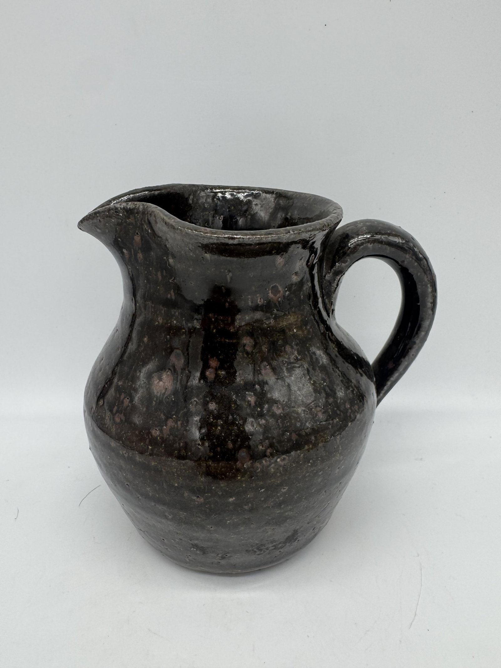 Arie Meaders Pitcher: A classic pitcher by Arie Meaders, made circa the mid-1960s. This piece features a rich, deep glaze that gives the piece character. Signed.