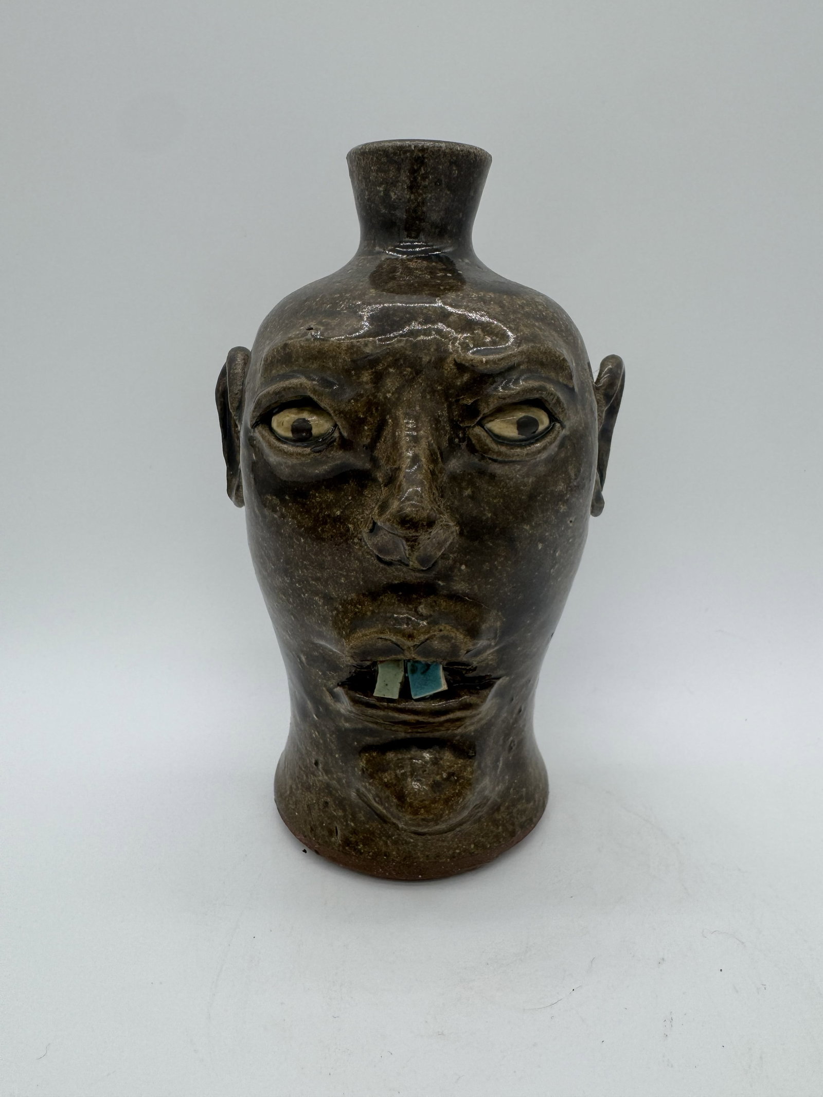 David Meaders Face Jug: A face jug by David Meaders, featuring an unusual form that sets it apart from more typical examples. This piece includes blue china plate teeth. Signed