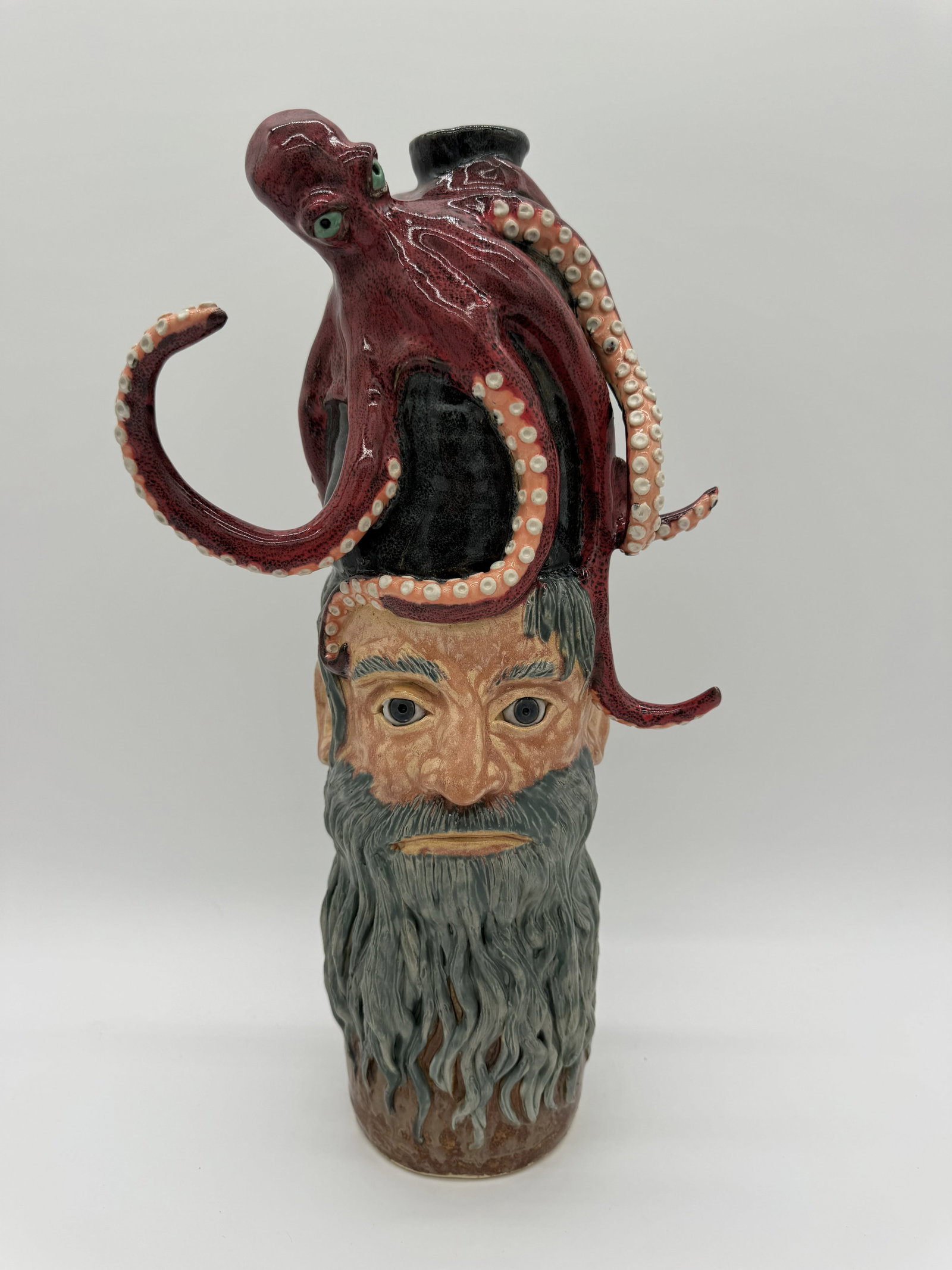 Lolly Lynn Sea Captain with Octopus Face Jug: A one-of-a-kind face jug by Lolly Lynn, depicting a bearded sea captain with an octopus perched on his head. The piece shows strong detail across the form, giving it character and visual interest.