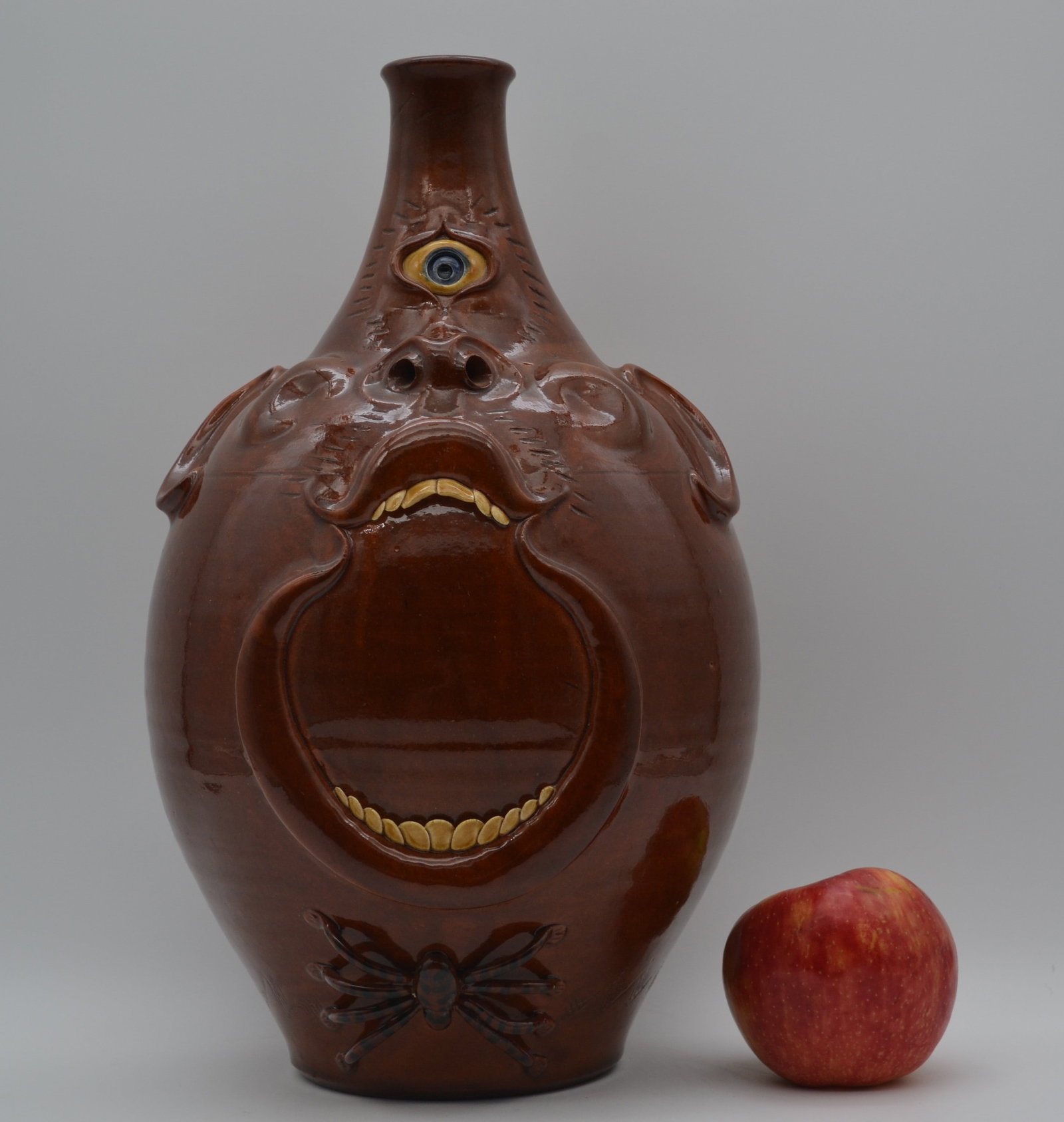 Roger Corn #10 Cyclops Face Jug: A very unique Cyclops face jug by Roger Corn. This is an especially notable example, as only ten Cyclops jugs were made. Numbered 10 of 10, this piece is also the first example with an attached spider