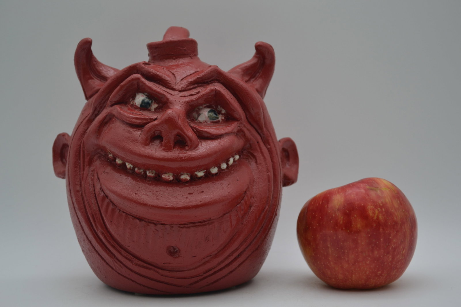 Clete Meaders Red Devil Face Jug: A Cleat Meaders red devil face jug, dated 2007. Cleat, son of C.J. and Billy Meaders, carried on the family pottery tradition while developing his own distinctive style. This example is especially not