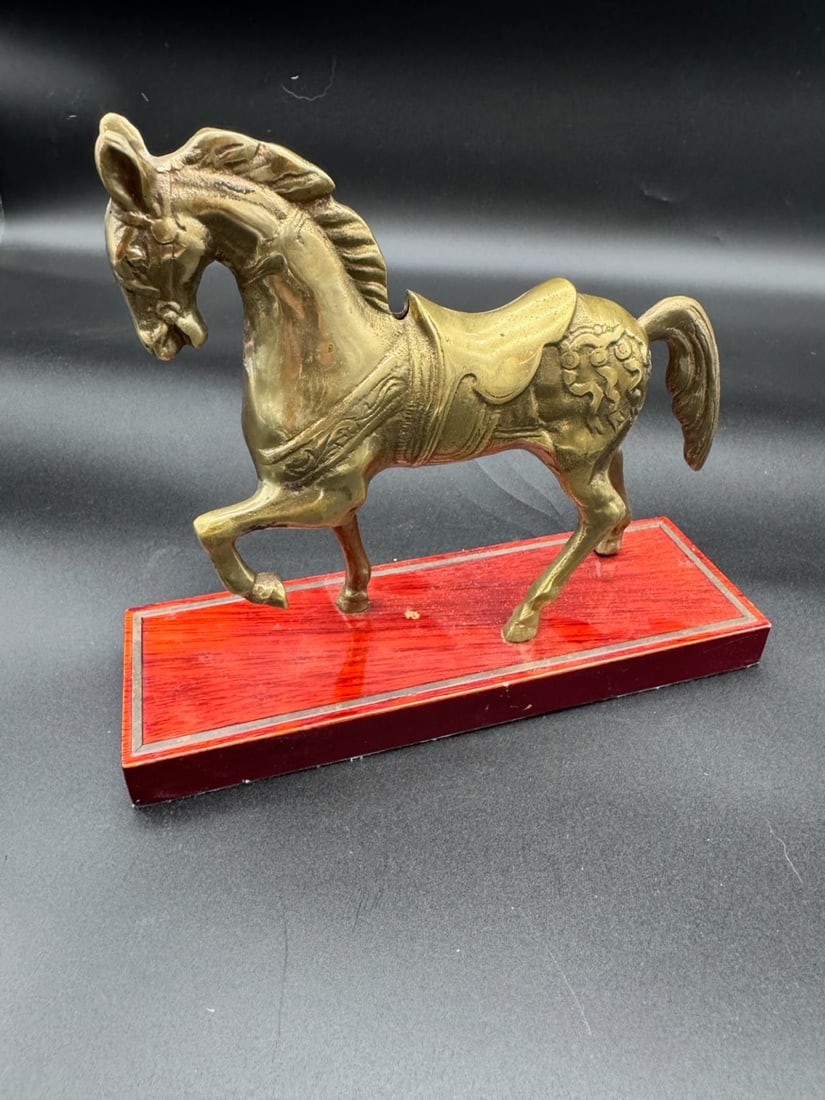 VINTAGE BRASS CAROUSEL MANTLE HORSE ON WOOD BASE: This item is a vintage brass horse figurine mounted on a red wooden base, likely functioning as a decorative tabletop or shelf display. Material: Solid or hollow cast brass horse with a wooden