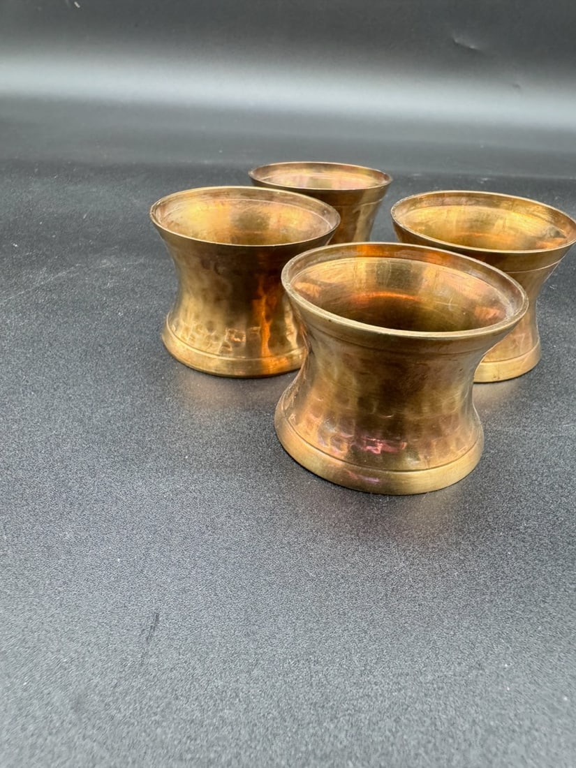 Hammered Brass Napkin Rings (Set of 4): This is a hammered brass napkin ring set of 4, with a flared design. Tapered in the middle to hold the napkins in place.